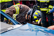 Firefighter leaning over to look in a car