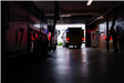 Two fire trucks exiting inside of fire station garage